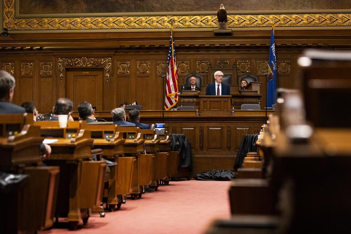 Wisconsin Gov. Tony Evers talks to people seated in a room