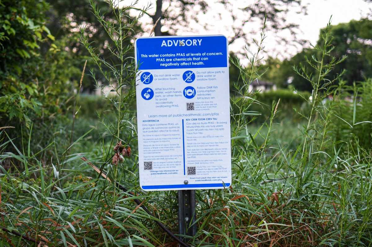 Advisory sign in front of greenery